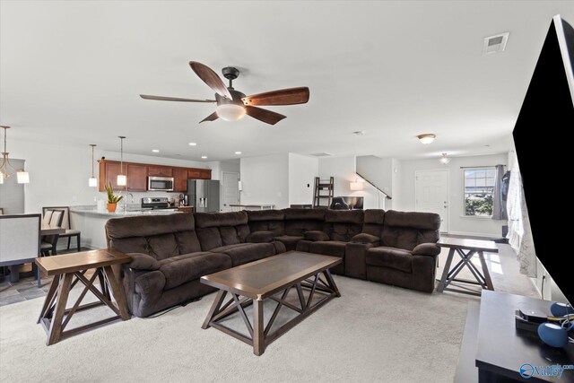 living room with light carpet and ceiling fan