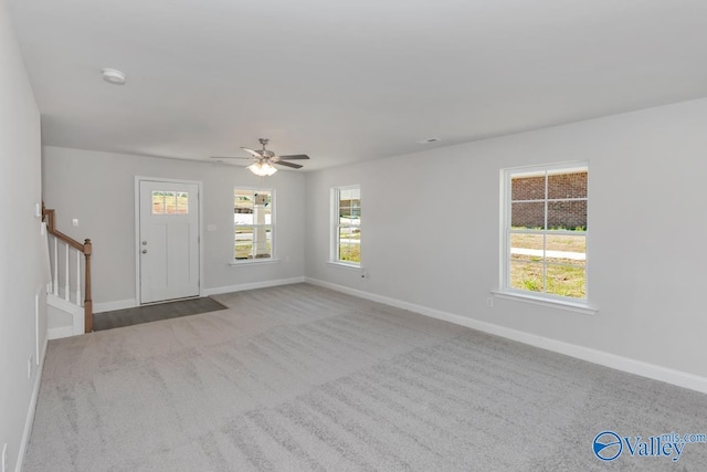 interior space with ceiling fan, stairway, and baseboards