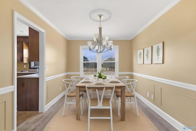 dining area featuring a chandelier, crown molding, and wood-type flooring