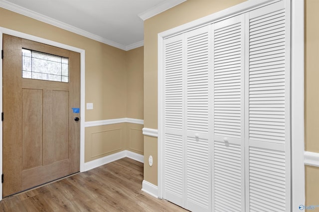 entrance foyer with crown molding and light hardwood / wood-style floors