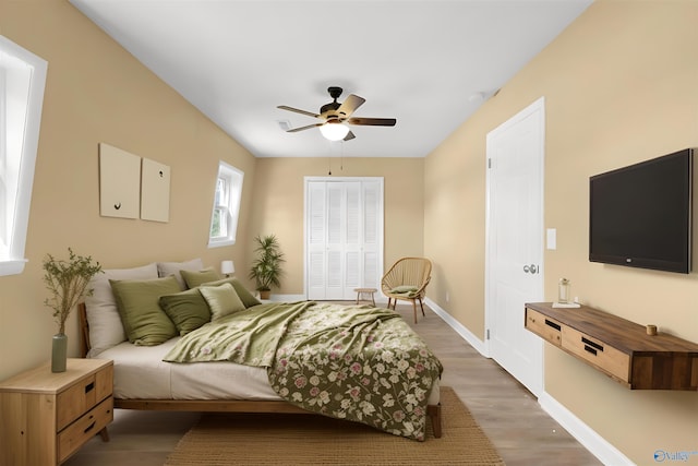 bedroom with ceiling fan, a closet, and wood-type flooring