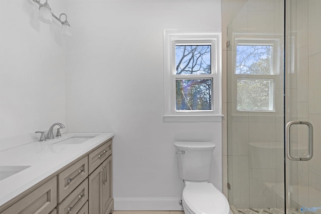 bathroom featuring toilet, a shower with door, and vanity