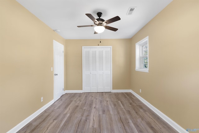 unfurnished bedroom featuring ceiling fan, a closet, and light hardwood / wood-style floors