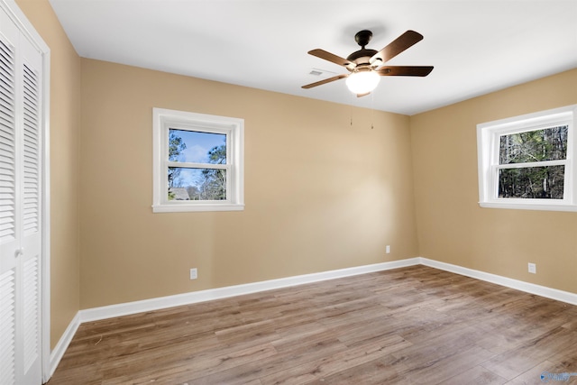 unfurnished bedroom with ceiling fan, a closet, and light wood-type flooring