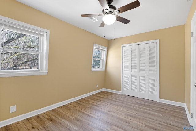 unfurnished bedroom with ceiling fan, light hardwood / wood-style floors, and a closet