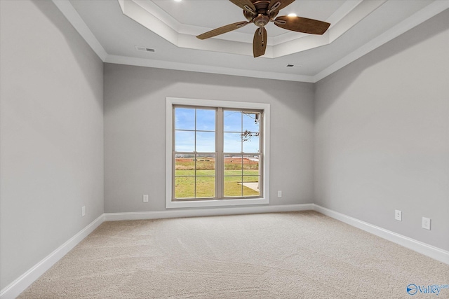 empty room with carpet, ceiling fan, and a tray ceiling