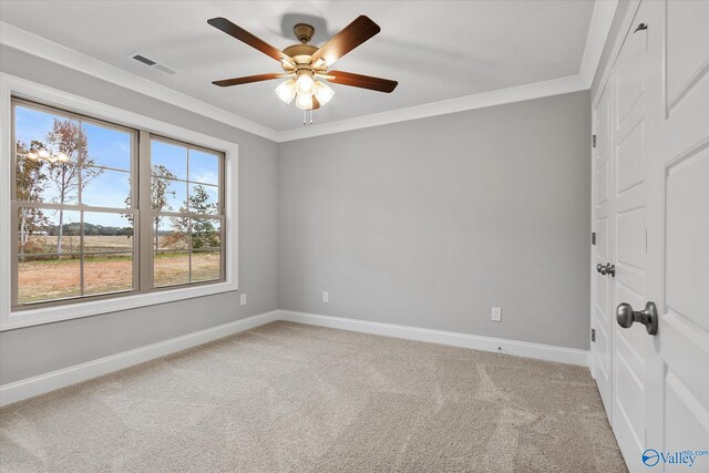 unfurnished bedroom featuring light carpet, a closet, ceiling fan, and crown molding