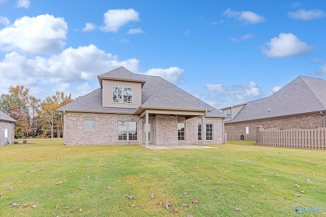 rear view of property featuring a patio and a lawn