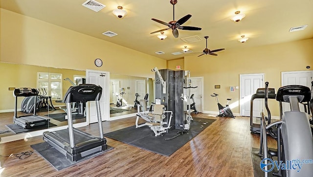 exercise room featuring a high ceiling, hardwood / wood-style flooring, and ceiling fan