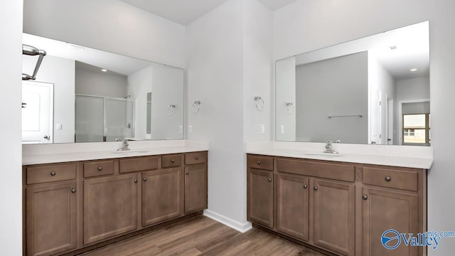 bathroom featuring wood-type flooring, vanity, and a shower with shower door