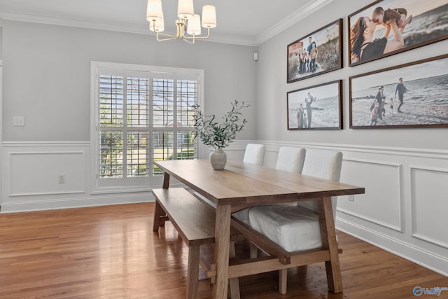 dining room with a decorative wall, plenty of natural light, a chandelier, and crown molding