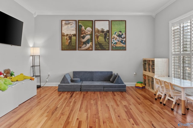 living room featuring baseboards, crown molding, and wood finished floors