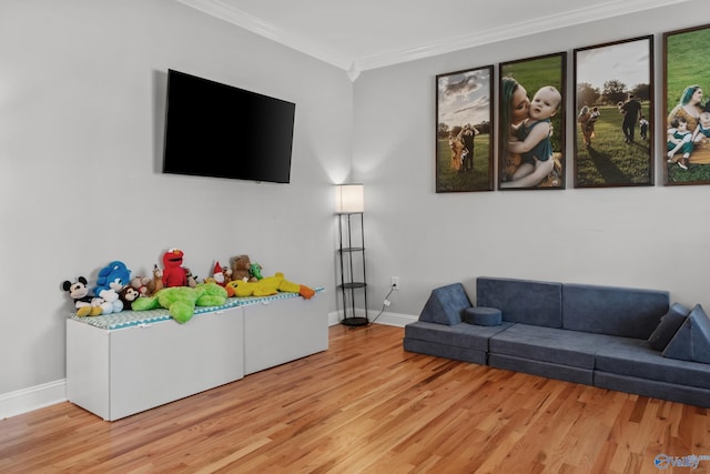 living room with light wood-type flooring, baseboards, and ornamental molding