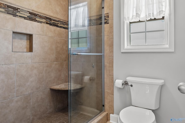 bathroom with toilet and a stall shower