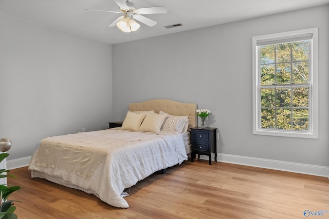 bedroom featuring visible vents, baseboards, and light wood finished floors