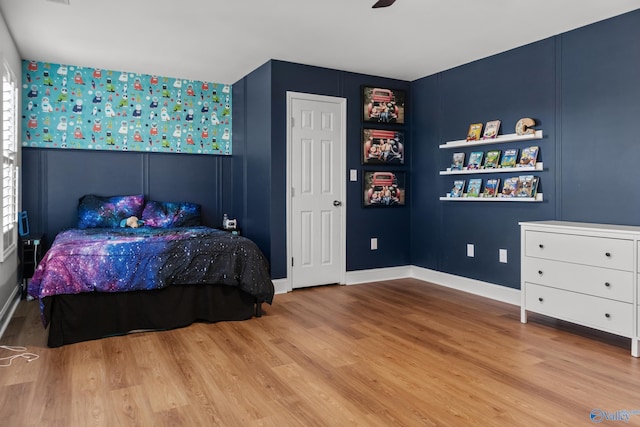 bedroom with multiple windows and wood finished floors