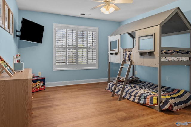 bedroom featuring wood finished floors, ceiling fan, baseboards, and visible vents