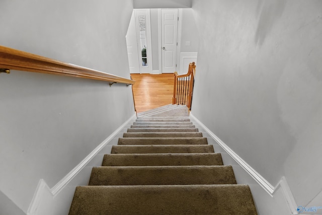 stairs featuring wood finished floors