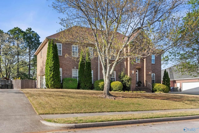 view of front of house featuring a front yard, fence, and brick siding