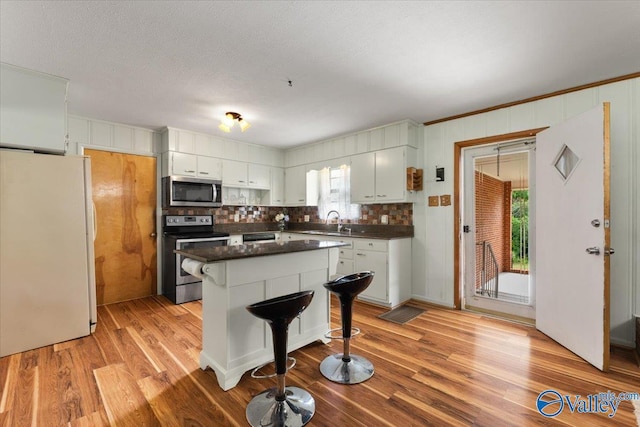 259 Old Big Cove Rd, Brownsboro, AL 35741 - kitchen with stainless steel appliances, a sink, dark countertops, light wood-type flooring, and backsplash