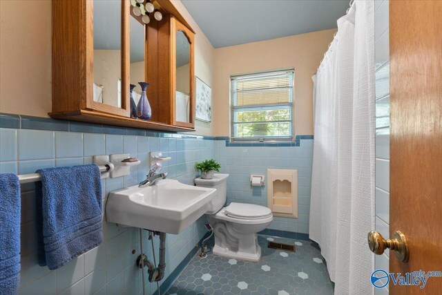 259 Old Big Cove Rd, Brownsboro, AL 35741 - bathroom with toilet, wainscoting, tile walls, curtained shower, and tile patterned flooring