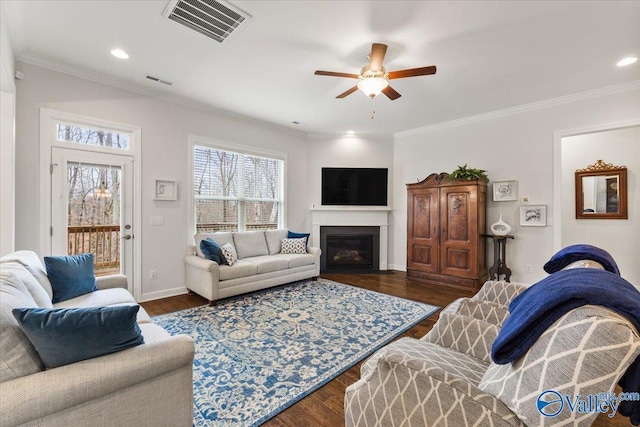 living room with visible vents, dark wood-style flooring, and ornamental molding