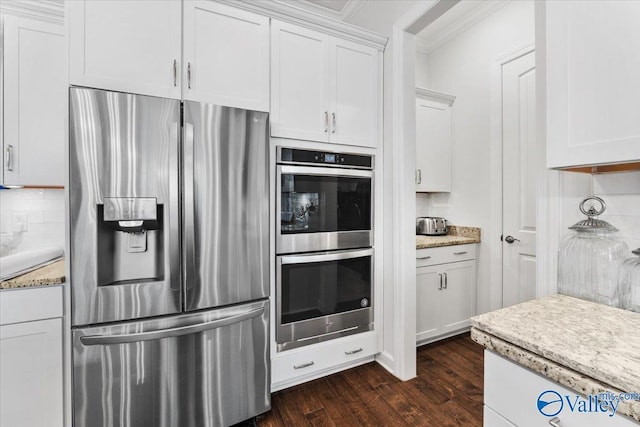 kitchen featuring stainless steel appliances, dark wood-type flooring, white cabinetry, tasteful backsplash, and crown molding