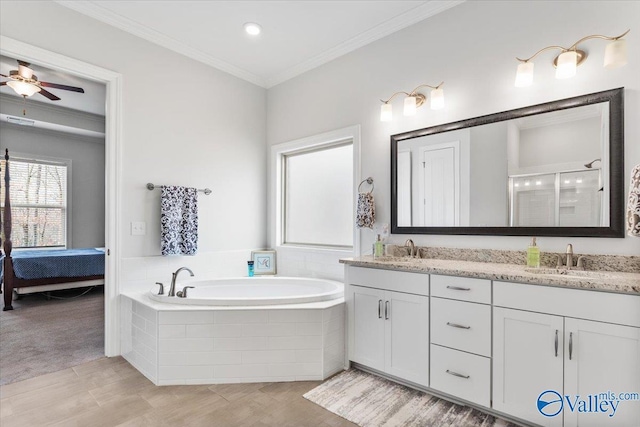 ensuite bathroom featuring double vanity, a stall shower, ornamental molding, a garden tub, and a sink