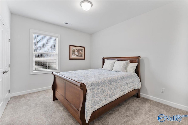 bedroom featuring light carpet, visible vents, and baseboards