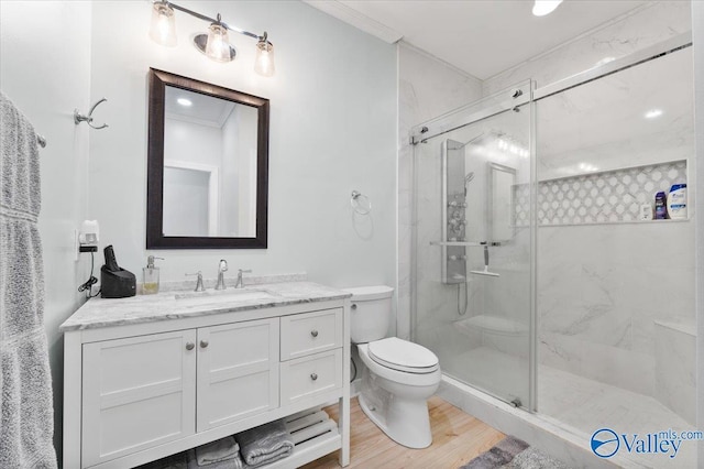 full bathroom featuring a stall shower, vanity, toilet, and wood finished floors