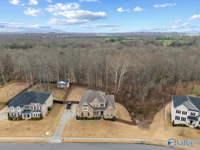 birds eye view of property featuring a forest view