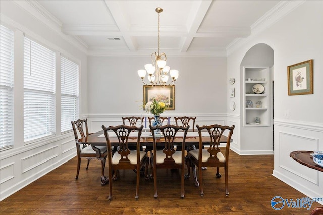 dining room featuring built in shelves, beam ceiling, wood finished floors, a chandelier, and coffered ceiling