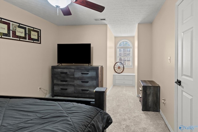bedroom with baseboards, a textured ceiling, carpet floors, ceiling fan, and visible vents