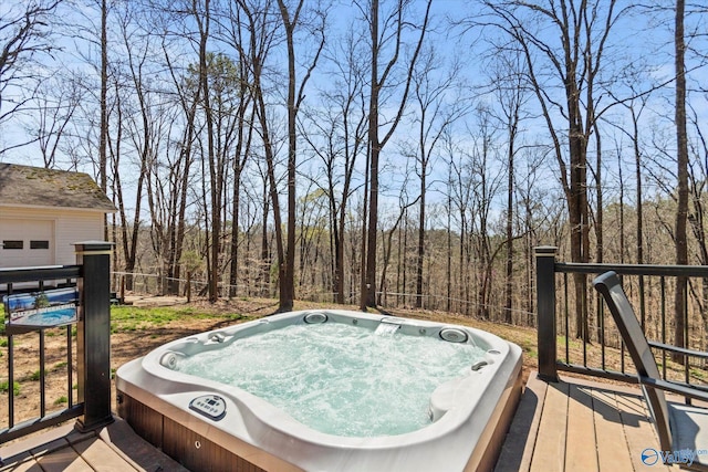 wooden deck with a wooded view and an outdoor hot tub