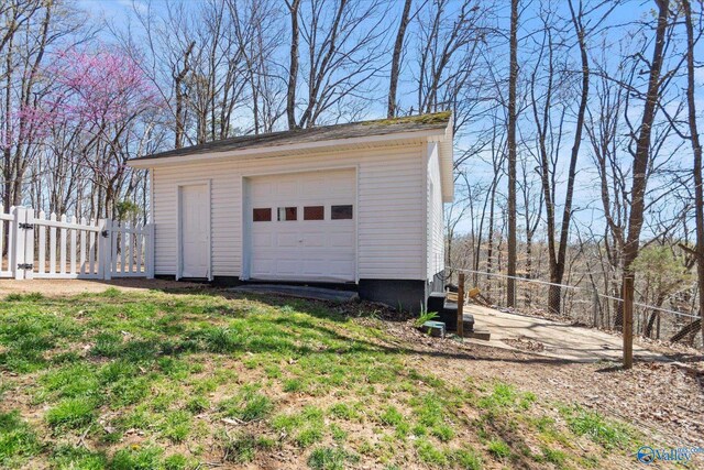 detached garage featuring a gate and fence