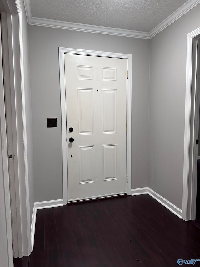 doorway featuring dark hardwood / wood-style floors, ornamental molding, and a textured ceiling