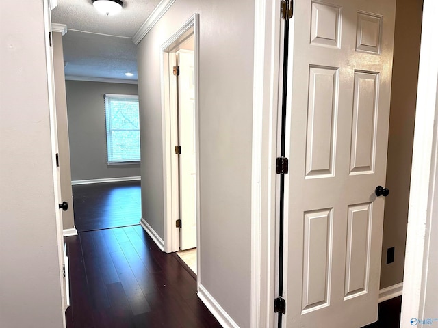 hall featuring a textured ceiling, dark hardwood / wood-style flooring, and crown molding