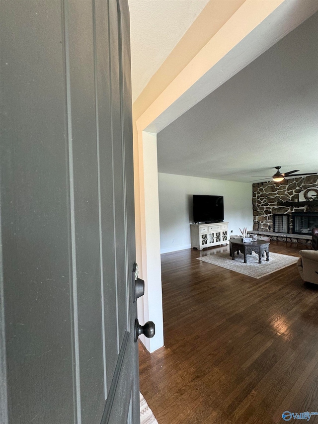 entryway featuring dark wood-type flooring and a stone fireplace