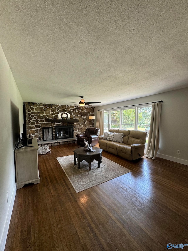 unfurnished living room with ceiling fan, a textured ceiling, a fireplace, and dark hardwood / wood-style floors