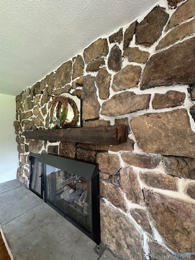 room details featuring a textured ceiling and a stone fireplace