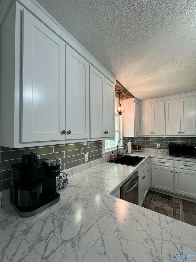 kitchen featuring decorative backsplash, dishwasher, white cabinetry, and sink