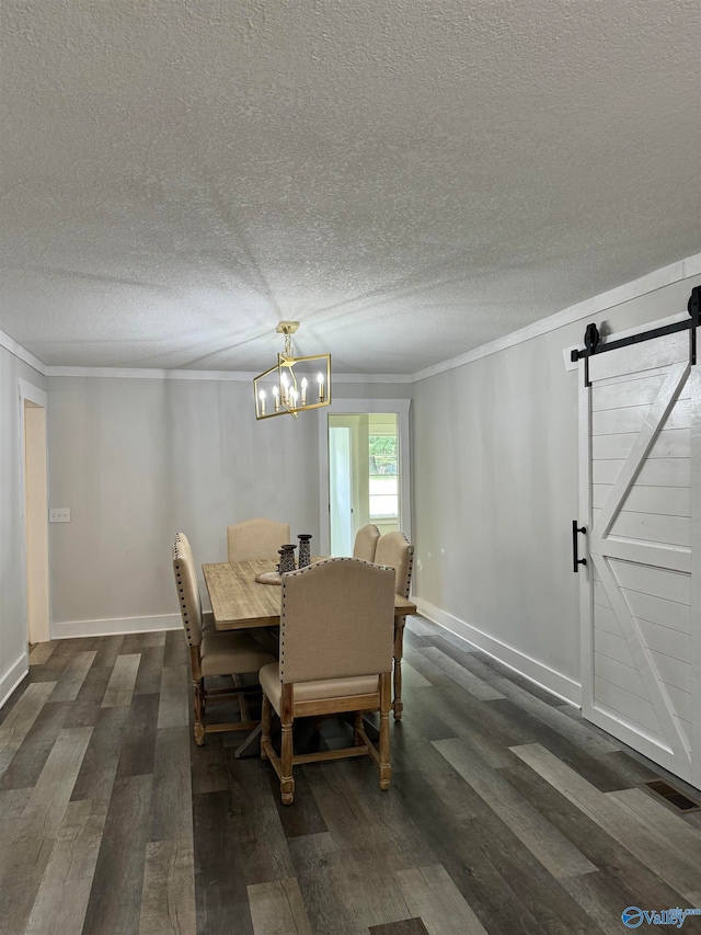 dining room with a textured ceiling, dark wood-type flooring, a notable chandelier, crown molding, and a barn door