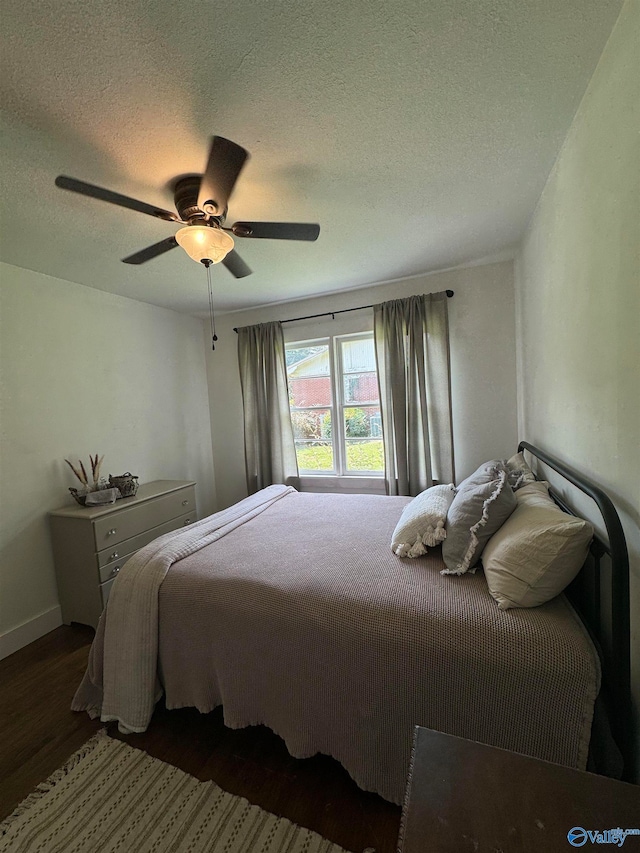 bedroom featuring a textured ceiling, dark hardwood / wood-style floors, and ceiling fan