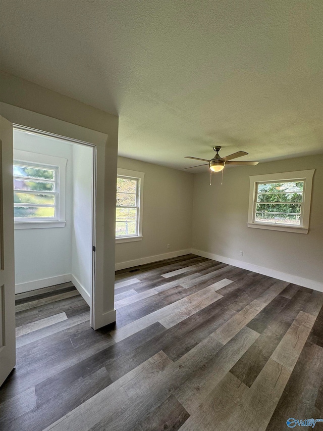 empty room featuring a textured ceiling, dark hardwood / wood-style flooring, and ceiling fan