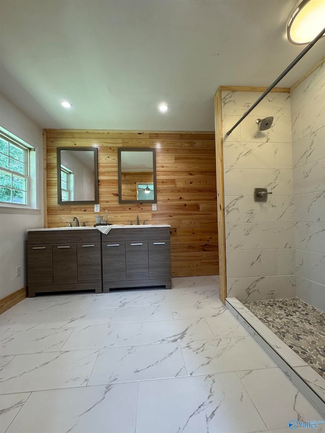 bathroom with wooden walls, vanity, and tiled shower