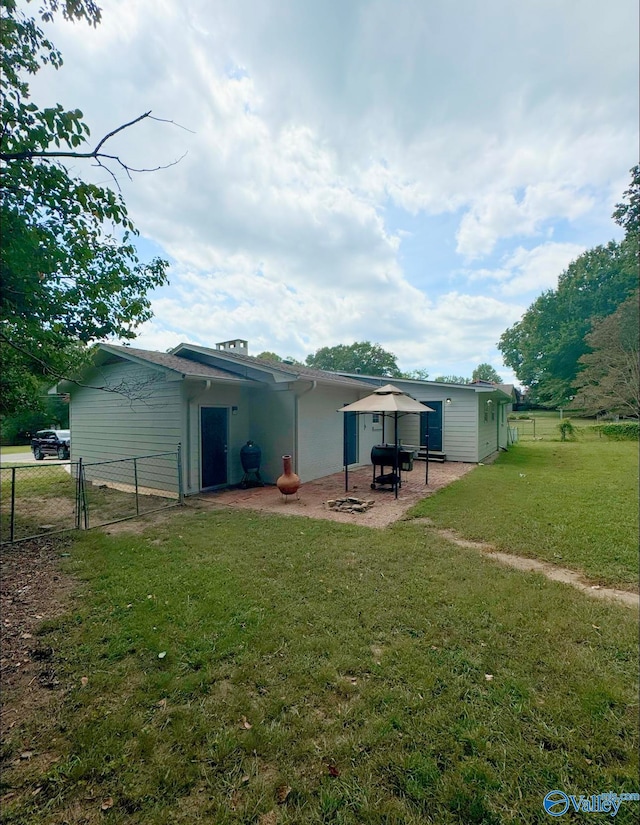 back of house with a lawn and a patio