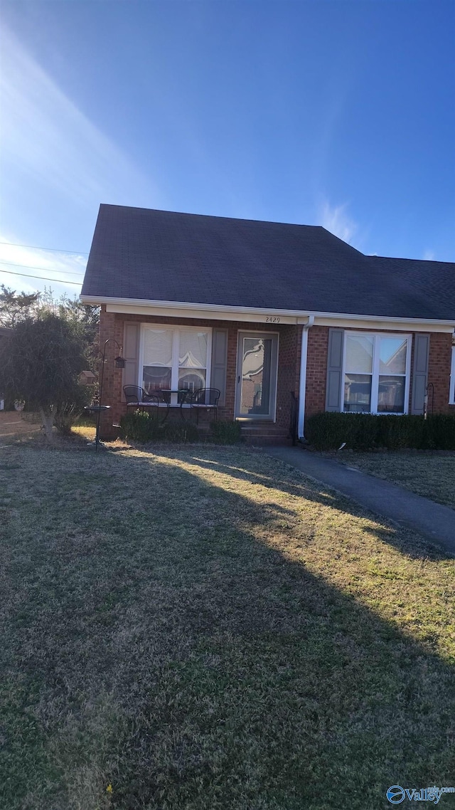 view of front of house with brick siding and a front lawn