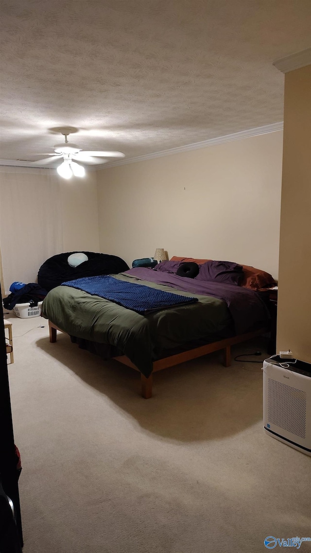 bedroom with carpet, crown molding, a textured ceiling, and ceiling fan