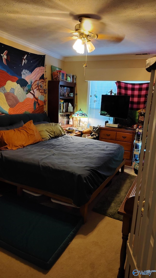 carpeted bedroom with a textured ceiling, a ceiling fan, and crown molding