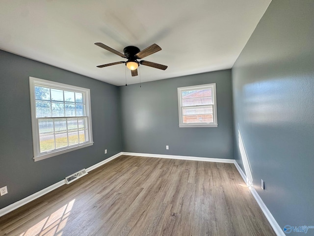 unfurnished room featuring a healthy amount of sunlight, ceiling fan, and light hardwood / wood-style flooring